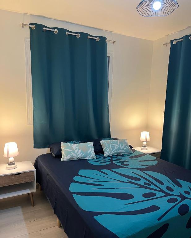 a bedroom with a blue bed with blue curtains at Honey Lodge in Punaauia
