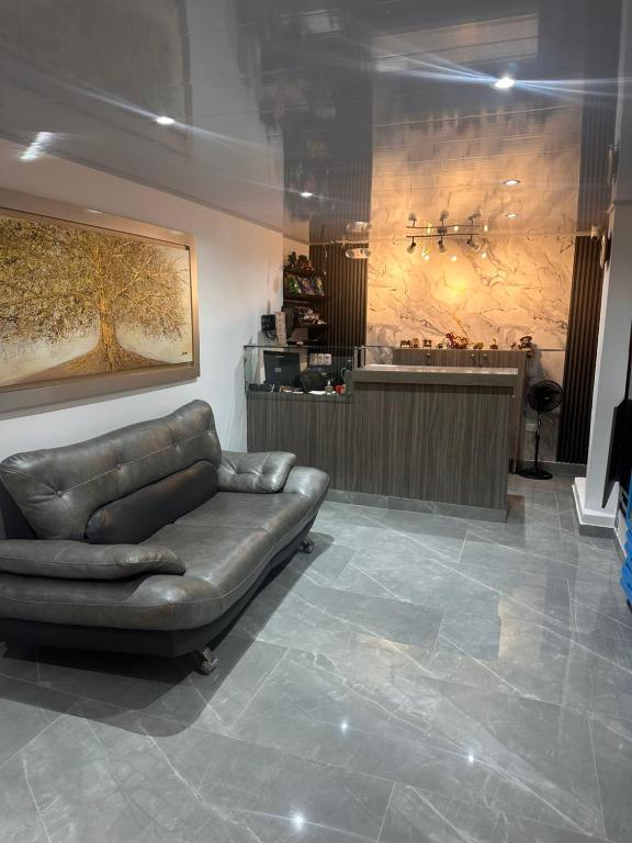 a leather couch sitting in a room with a salon at Hotel Confortel in Armenia