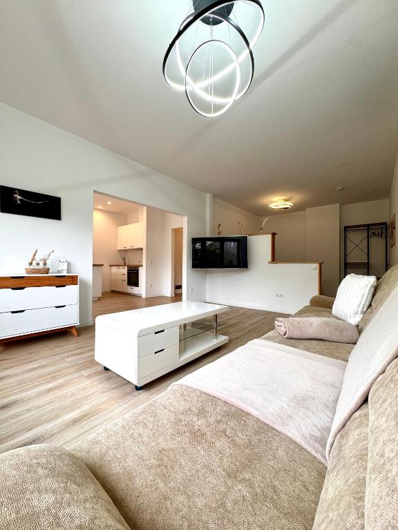 a large living room with two beds and a chandelier at Appartment in Freizeitpark in Wiesloch