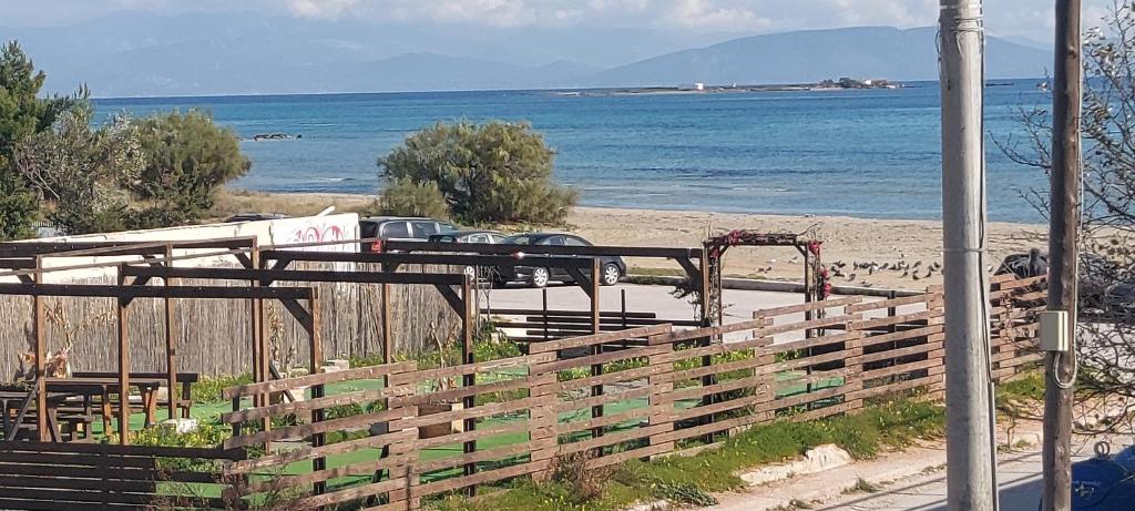 a view of a beach with a fence and the ocean at Seafront blue in Áyios Spirídhon