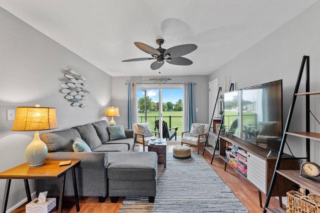 a living room with a couch and a ceiling fan at Beachside Condo w Stunning Lake Views in Sheboygan