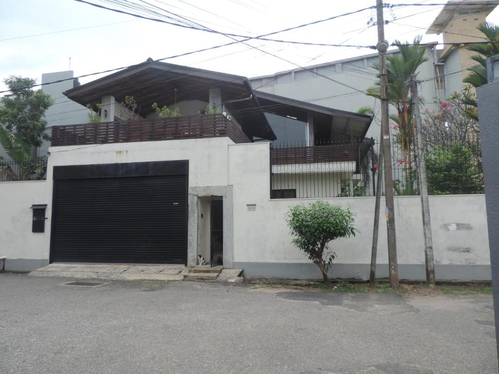 a white building with a garage door and a balcony at Mount Bliss Home Stay in Mount Lavinia