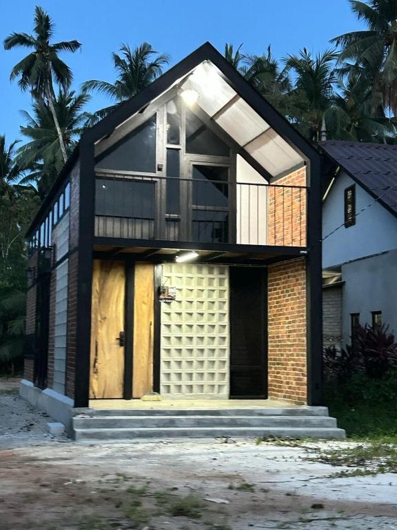 a house with a large door and a balcony at Tiny House in Kuala Terengganu