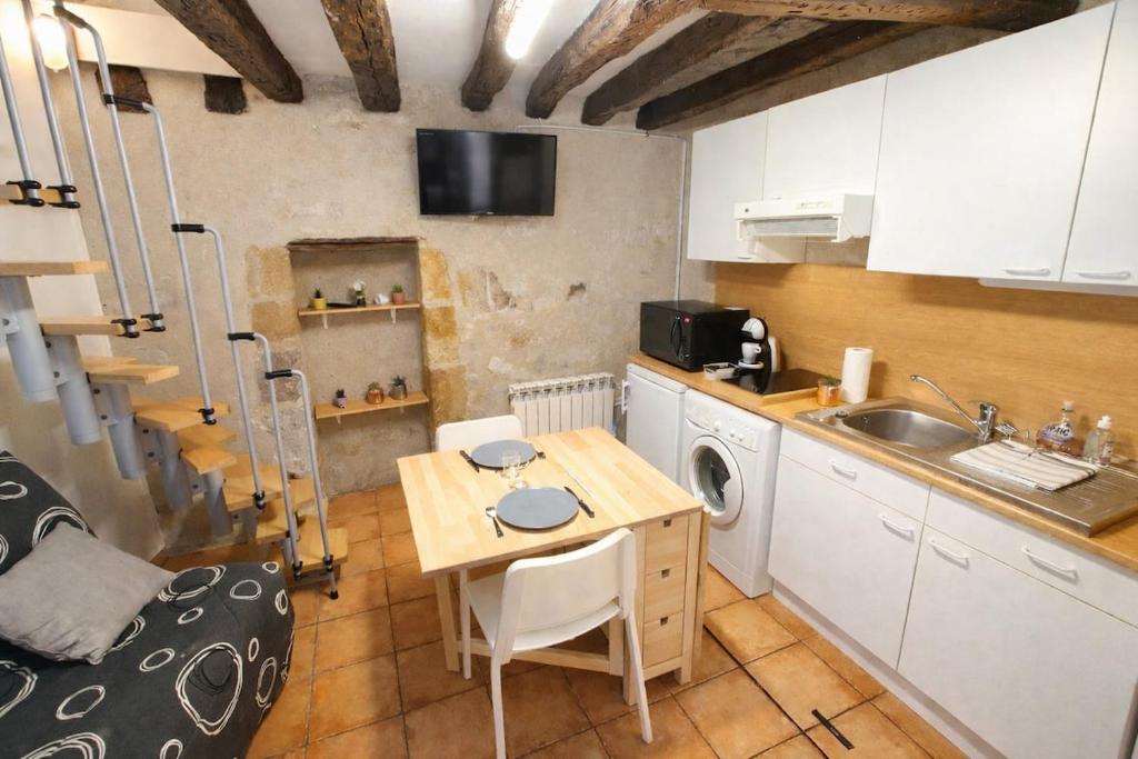 a small kitchen with a table and a sink at Le Nid Comtois in Vic-le-Comte