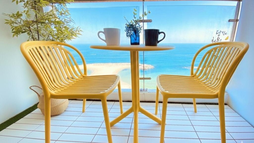 two chairs and a table in front of a window at 속초 오션뷰 써밋베이1205 in Sajin