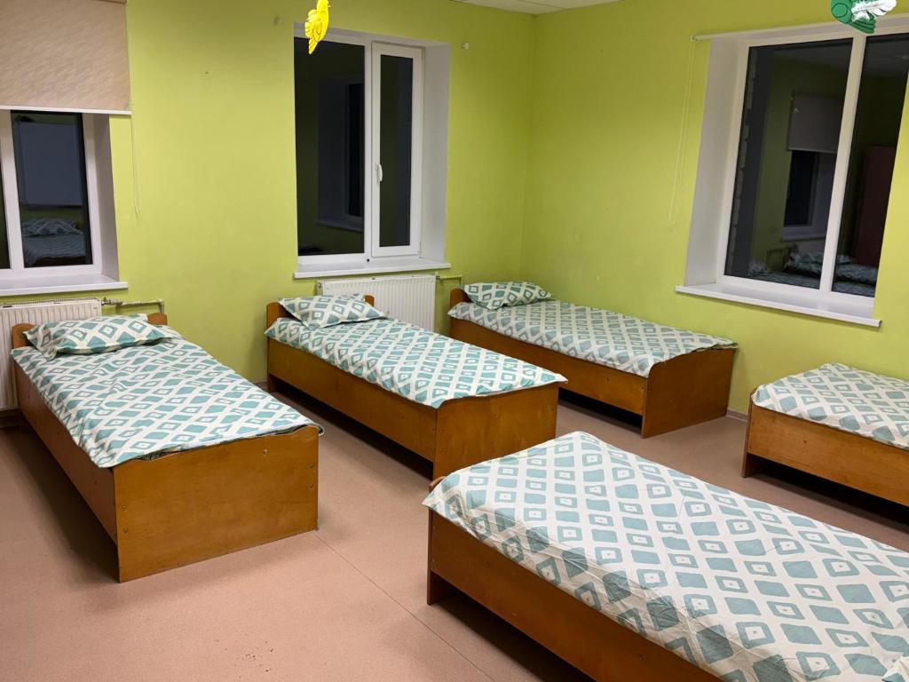 un gruppo di letti in una stanza con finestre di Nichi camp a Dekšāre