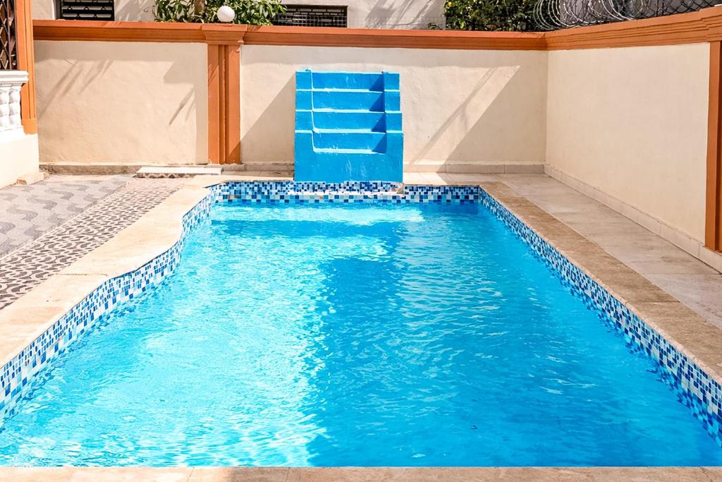 a swimming pool with a blue chair in the middle at Casa familiar con piscina y cerca de la playa in La Belleza