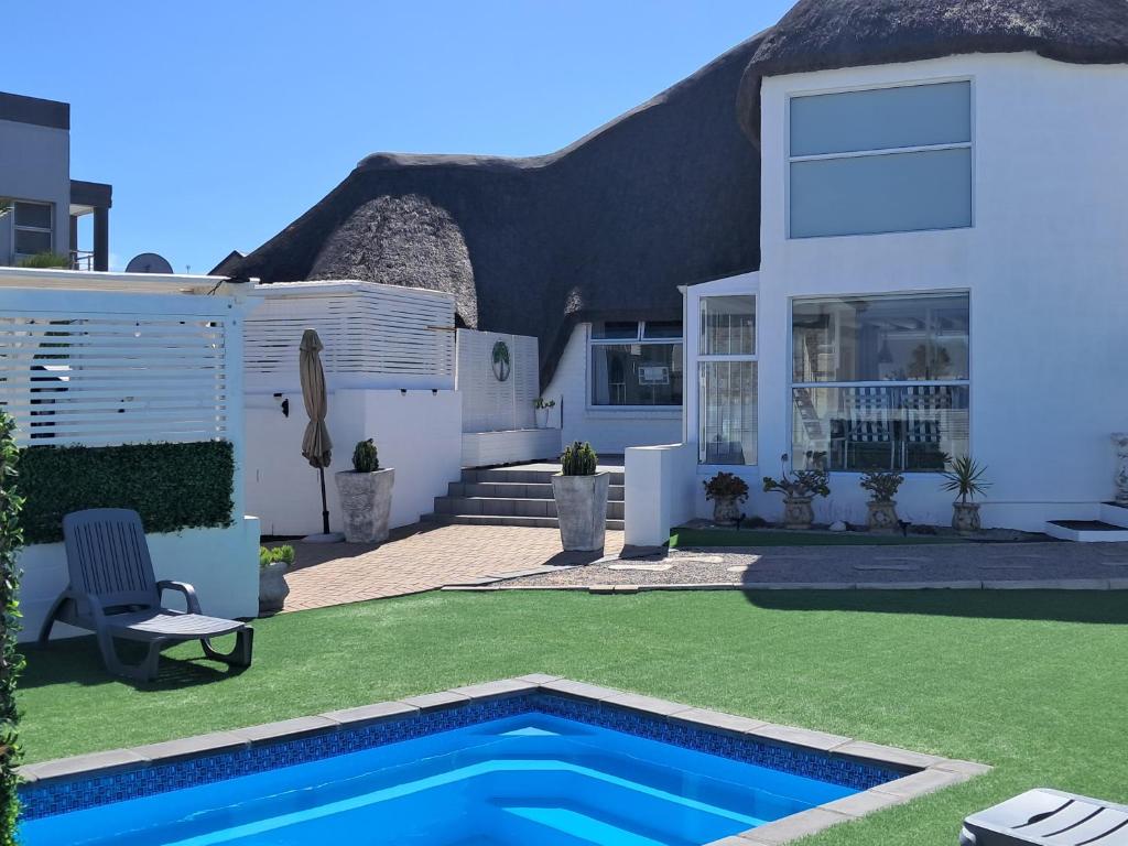 a house with a swimming pool in the yard at Beach Style Cottage in Langebaan