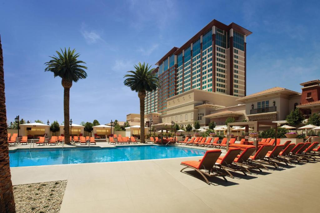 a hotel with a pool with chairs and palm trees at Thunder Valley Casino Resort in Lincoln