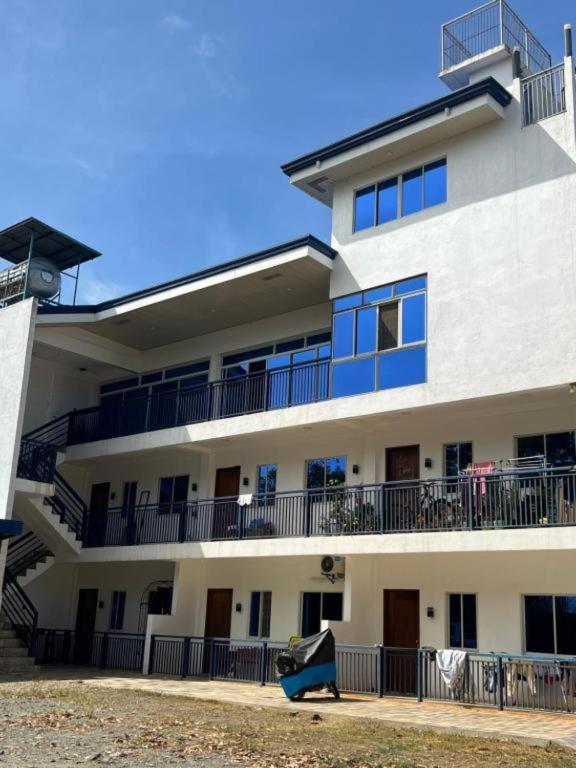 a large white building with balconies and a playground at Summers Lounge in Puerto Princesa City