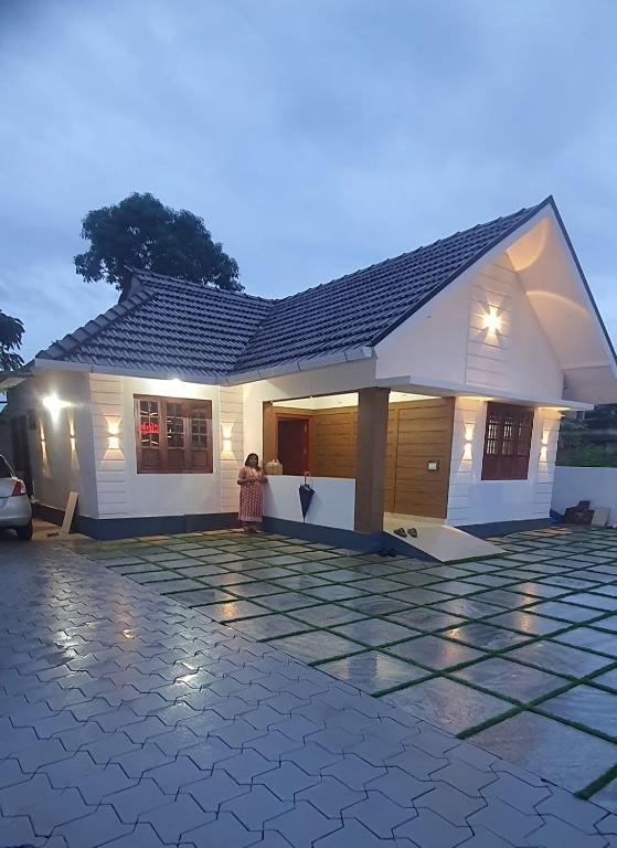 a woman standing in front of a house at Tender leaf inn in Koroth