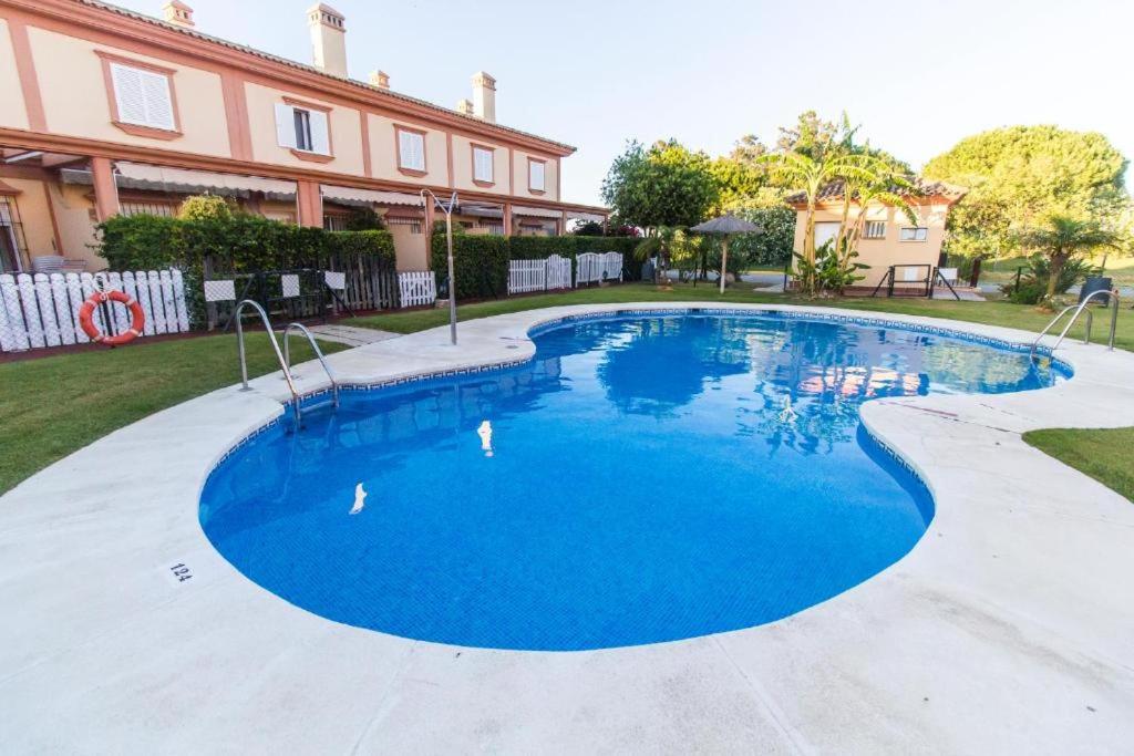 a pool with blue water in front of a house at Casa Costa Atlantica in Costa Ballena