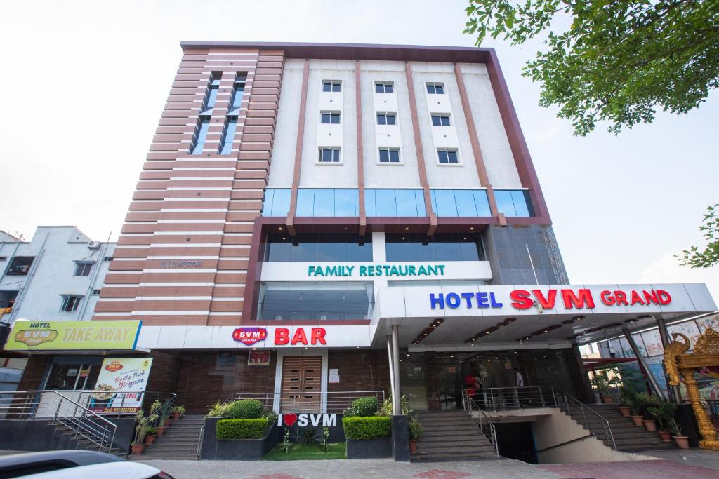a tall building with a hotel sign in front of it at Hotel SVM Grand Medipally in Upal