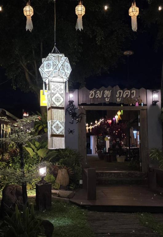 a clock hanging in front of a restaurant at night at Chomphu Phukha Resort-Mountain View Nan in Pua