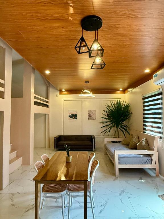 a living room with a table and a couch at Violegre Homestay - KABLON in General Luna