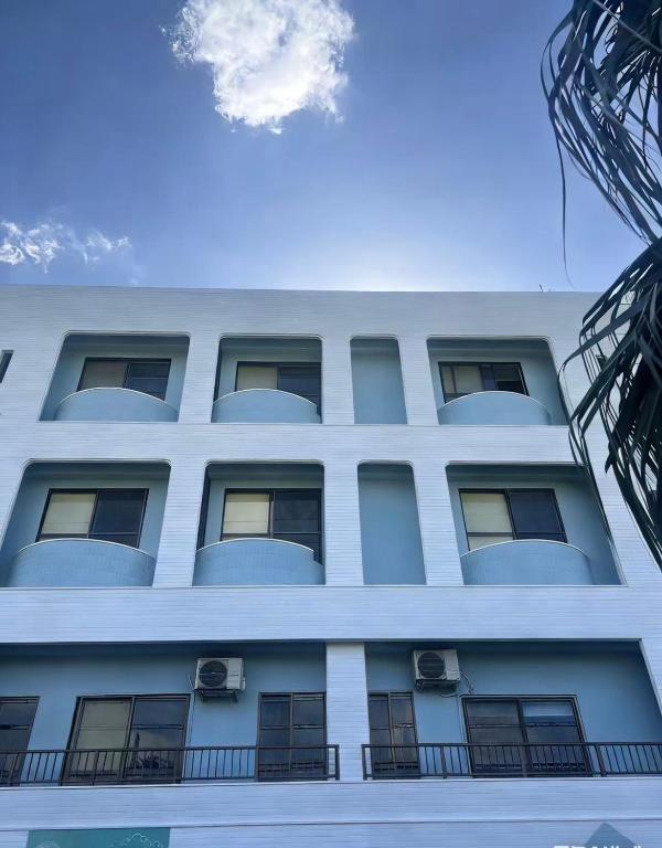 a white building with a balcony on the side of it at Hotel GALA Naha's only sandy beach front all rooms oceanview in Naha