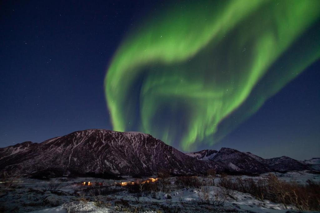 an image of the aurora in the sky over a mountain at Fredheim, Northern Light Lodge in Laukvik