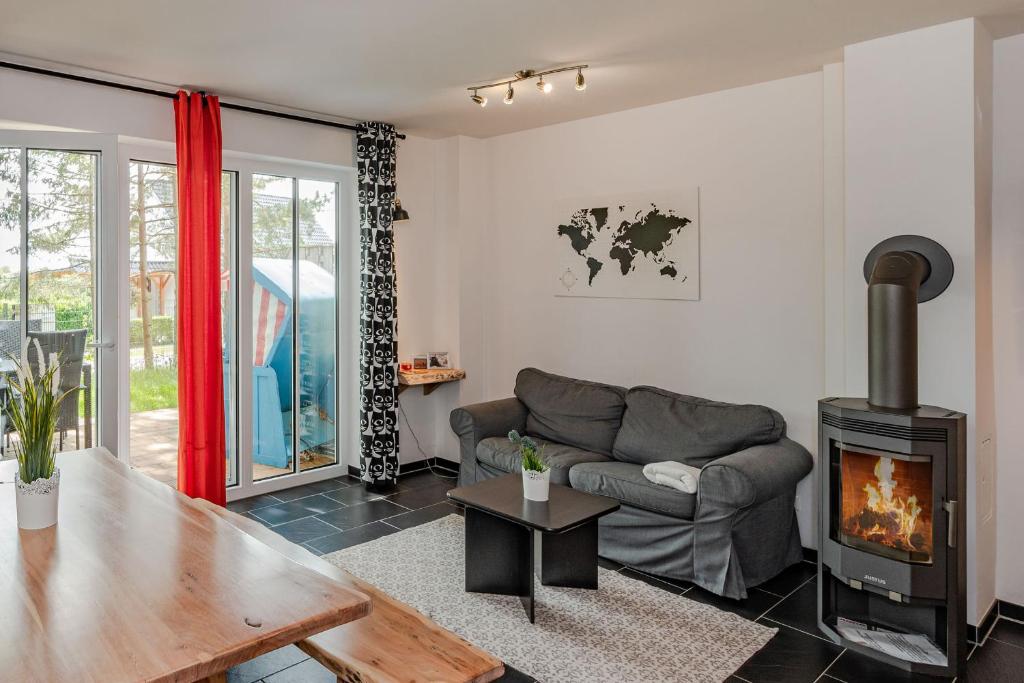 a living room with a couch and a fireplace at Ferienhaus Kontraste 4m in Korswandt