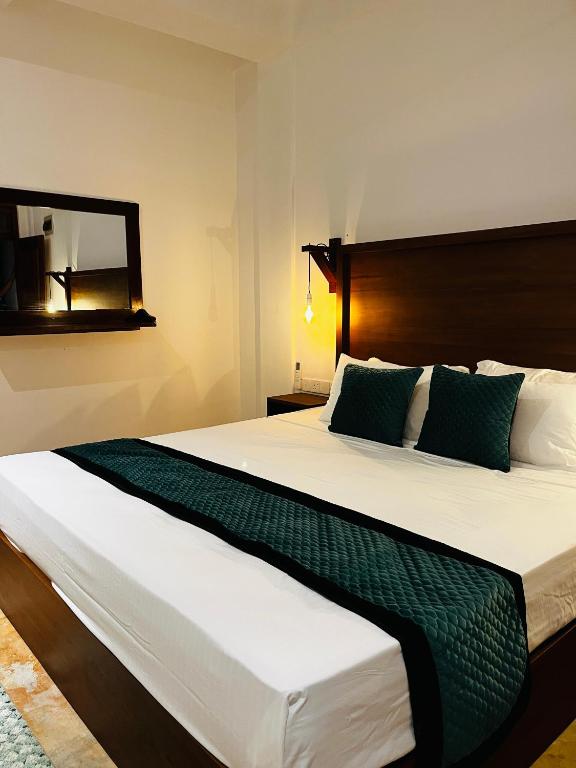 a bedroom with a large bed with a mirror at BlueTide Hiriketiya in Hiriketiya