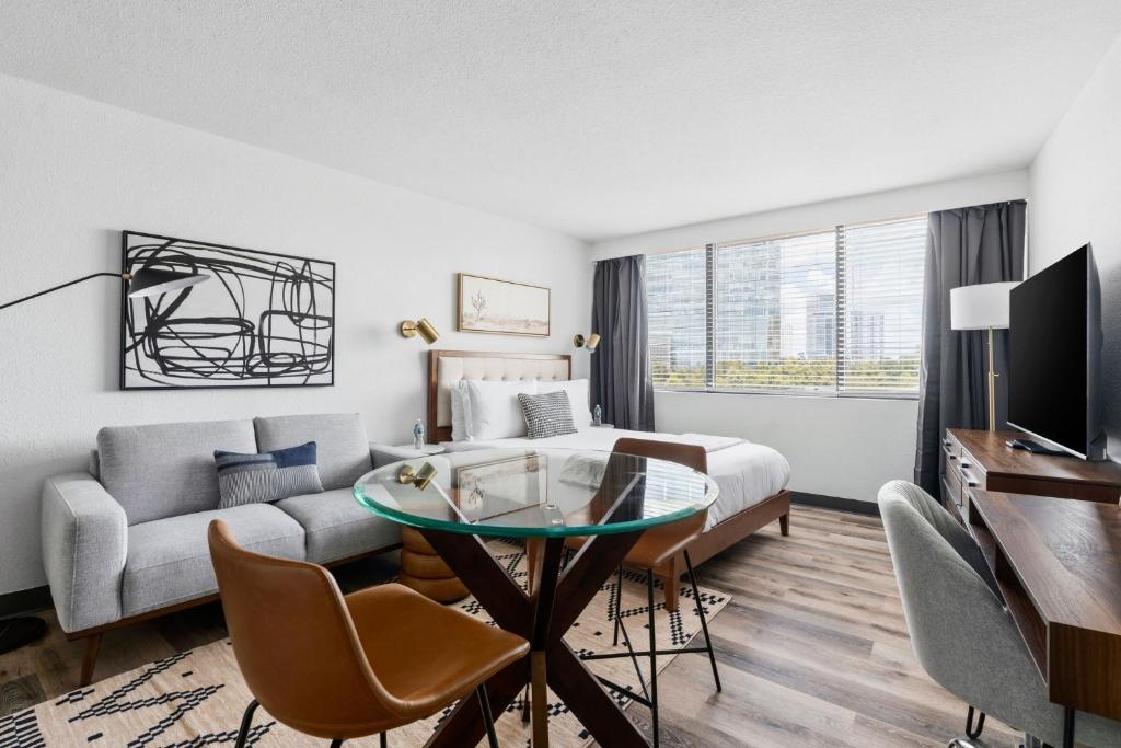 a hotel room with a bed and a table and a couch at Lodgeur Upper Kirby, Houston - Close to Greenway Plaza, Galleria, Montrose in Houston