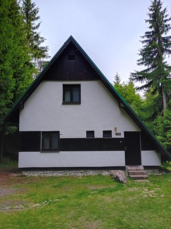 a large white house with a black roof at Chata Studnička in Jakubovany