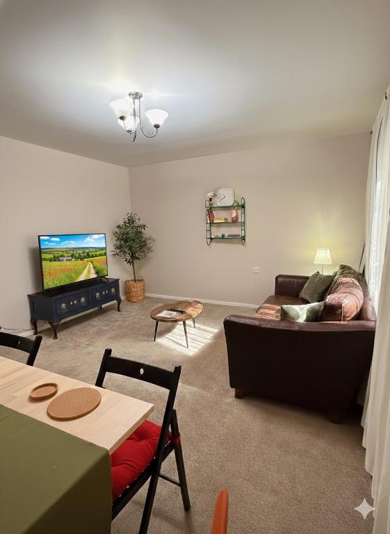 a living room with a couch and a flat screen tv at Stylish 3-Bed Maisonette - Sleeps 6 - Free Parking in Heswall
