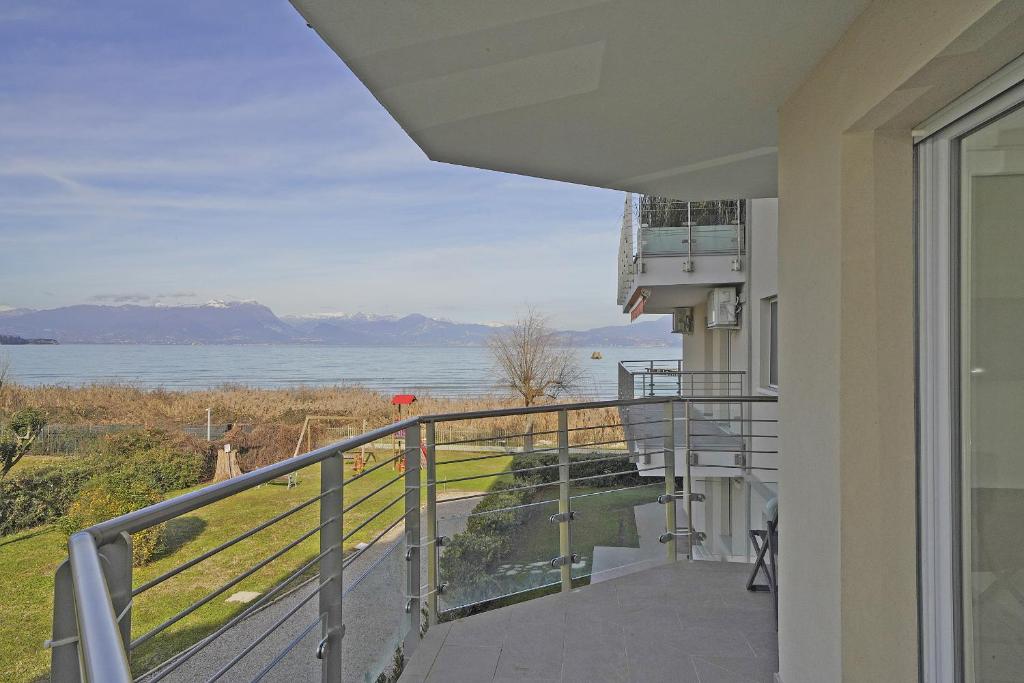 a balcony of a house with a view of the water at Sunset on Sirmione in Sirmione