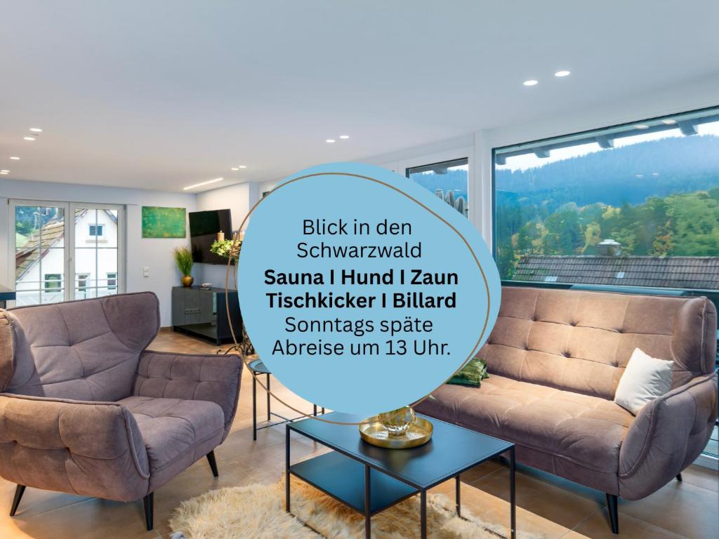 a living room with two chairs and a table at Waldklang Refugium Schwarzwald - eingezäunt - Außen-Sauna - Tischkicker - Billard in Alpirsbach