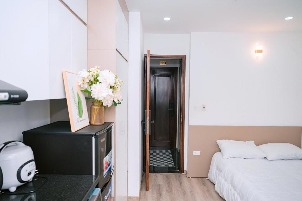 a bedroom with a bed and a tv with flowers at Auri House in Hanoi