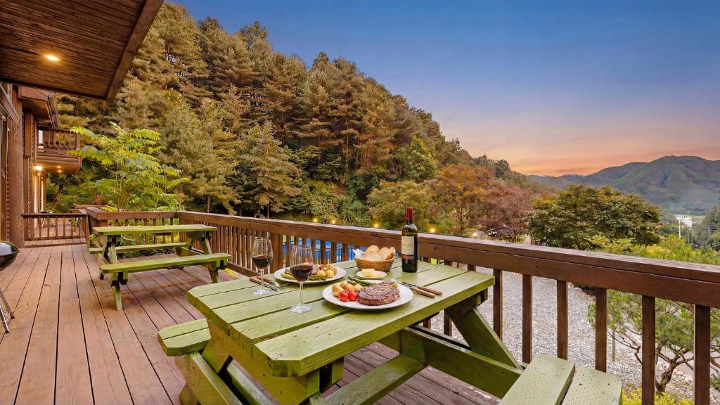 a picnic table with a plate of food on a deck at Gapyeong Humantown Pension in Gapyeong
