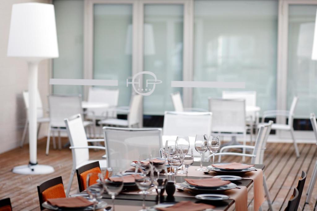 a dining room with a table with glasses and chairs at Hotel Praia in Nazaré
