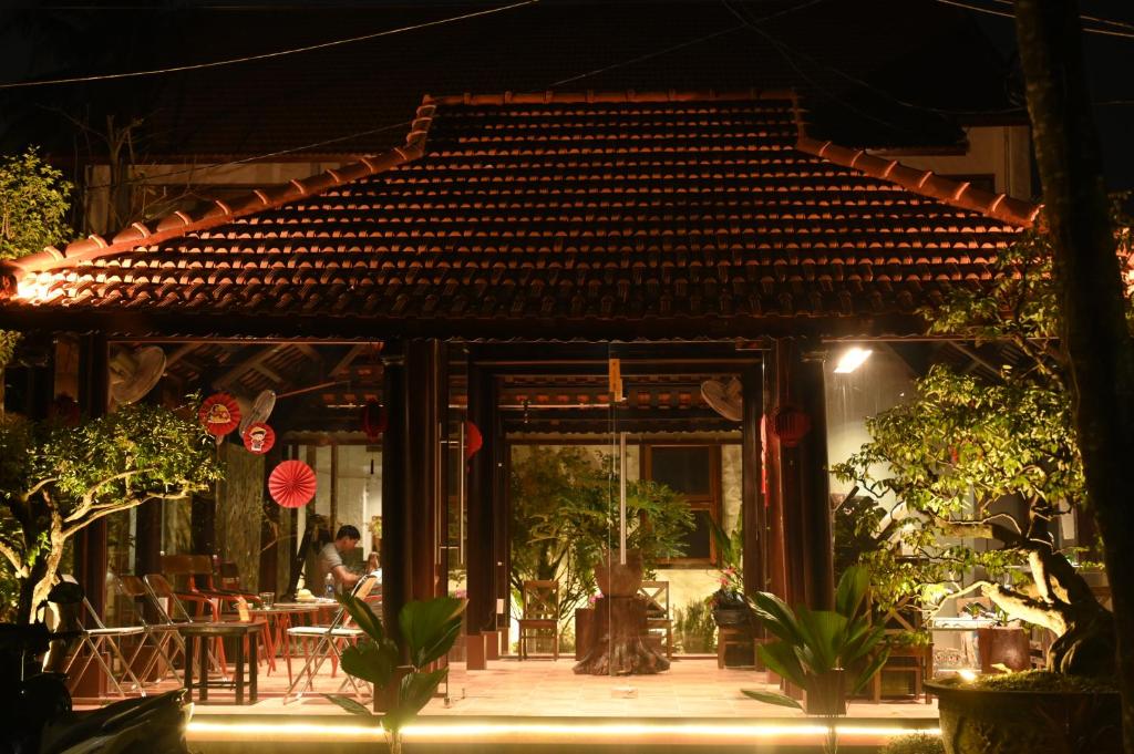 a patio with tables and chairs at night at Berry Boutique in Hue