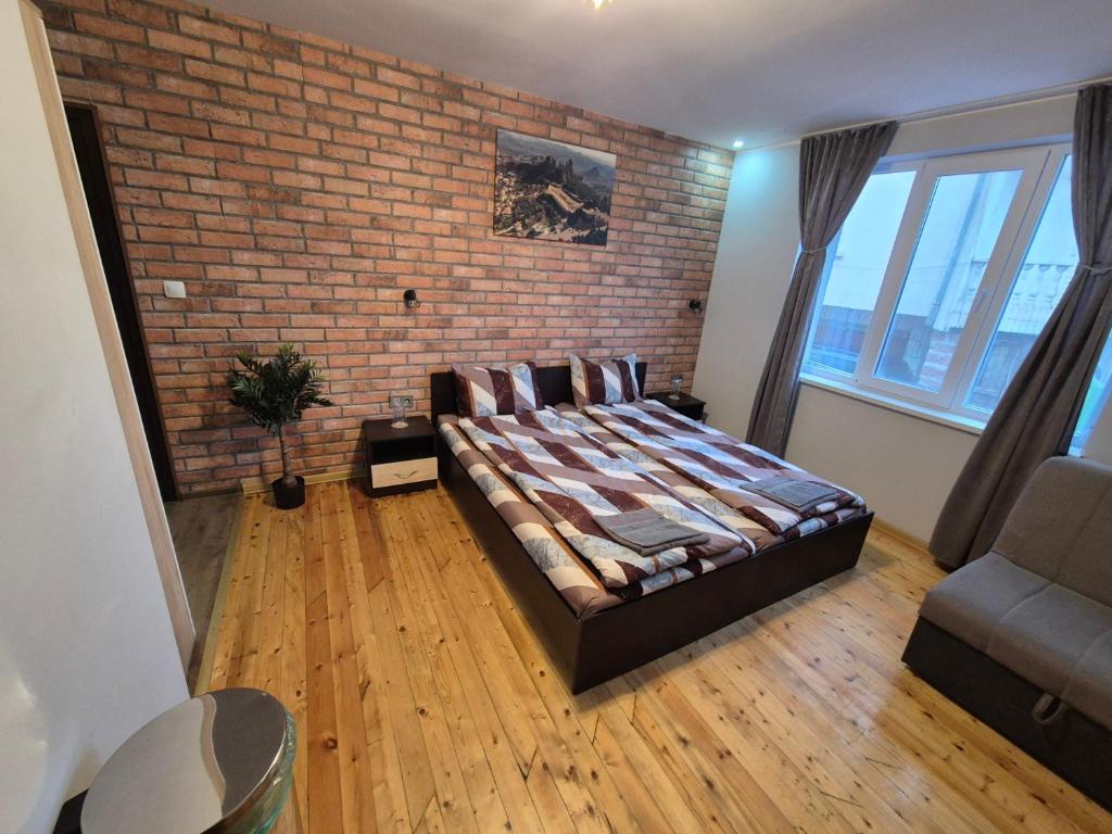 a bedroom with a bed and a brick wall at Къща за гости Белоградчик in Belogradchik