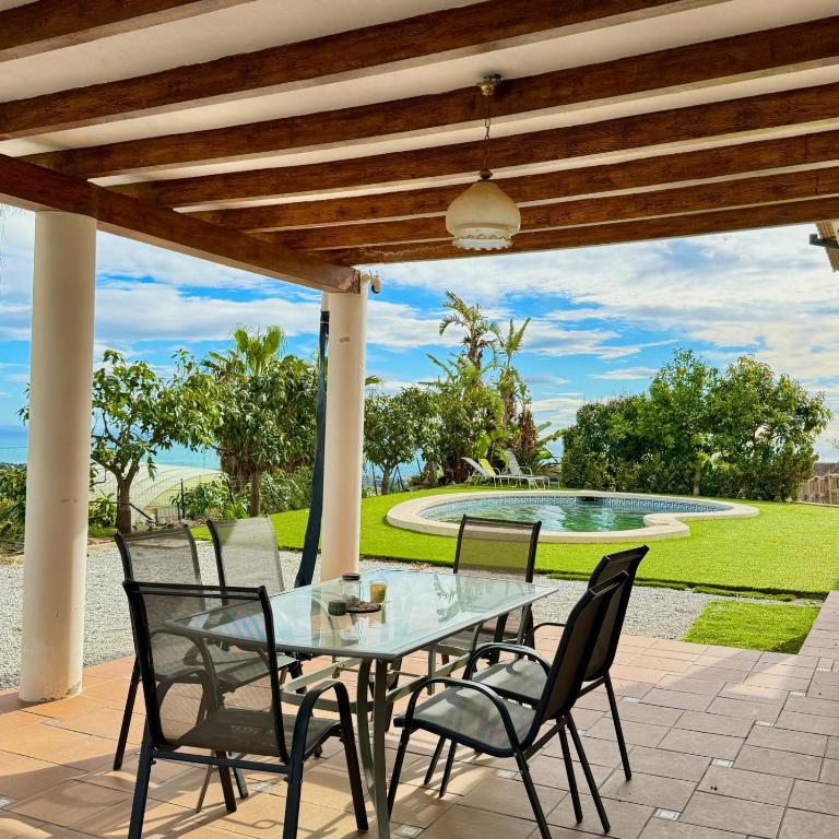 Ein Tisch und Stühle auf einer Terrasse mit einem Brunnen in der Unterkunft Casa Eclipse in Benajarafe