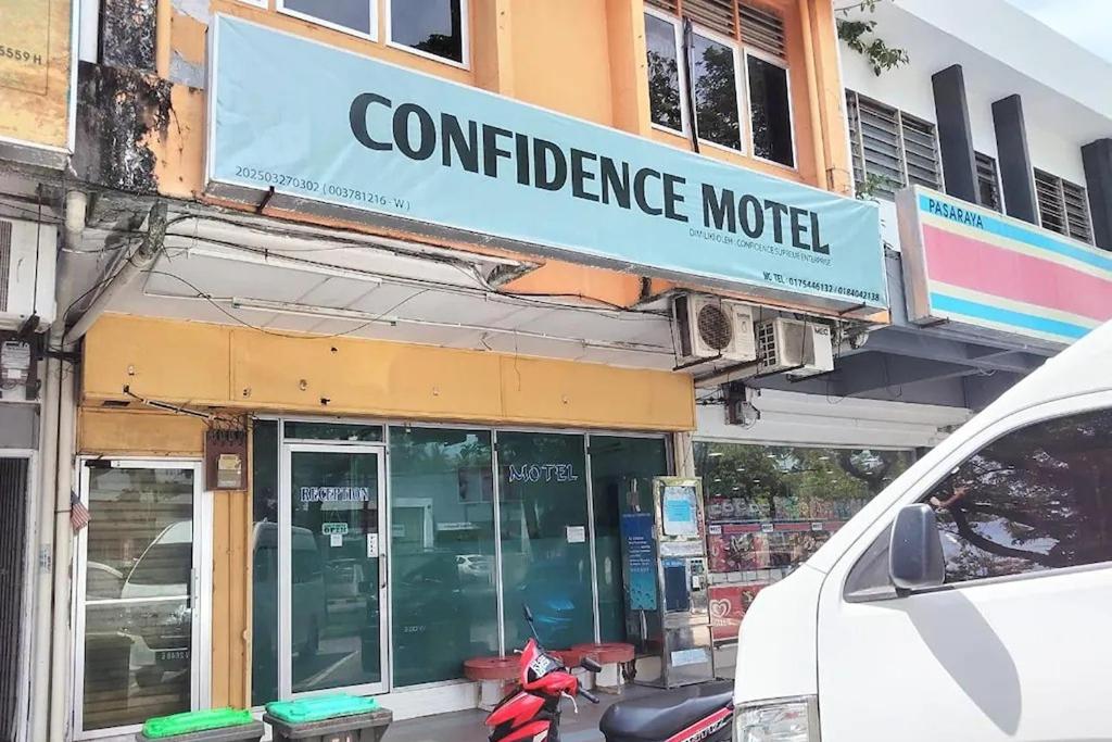a sign for a confidence motel on the side of a building at Confidence Motel in Kuah
