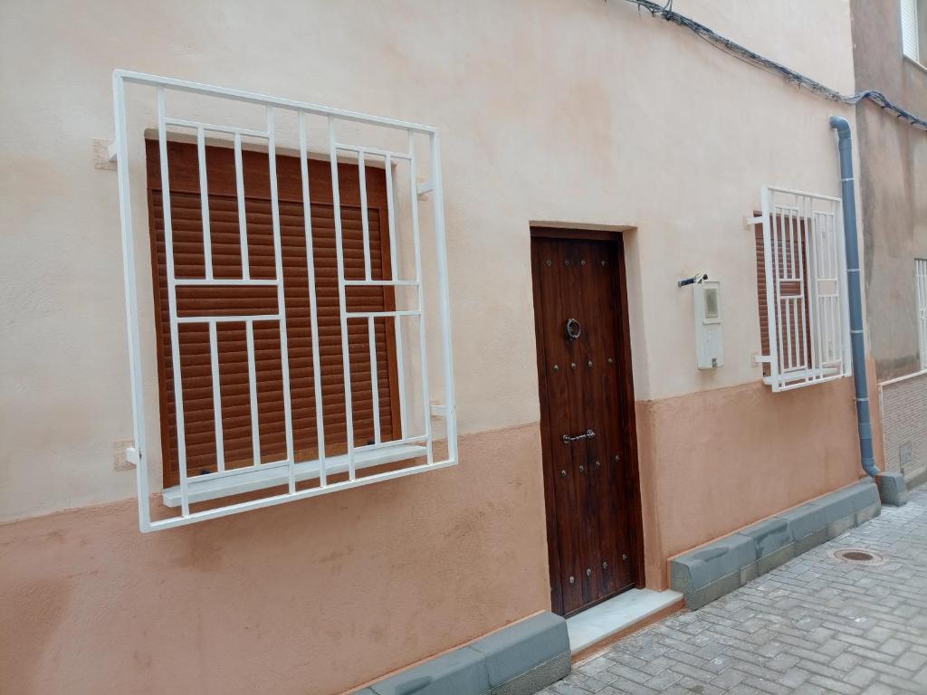 a building with a barred window and a door at Casa del Abuelo in Tabernas
