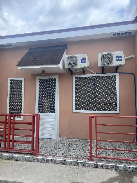 a house with a red fence in front of it at Kole & Kobe Haven in Dipolog