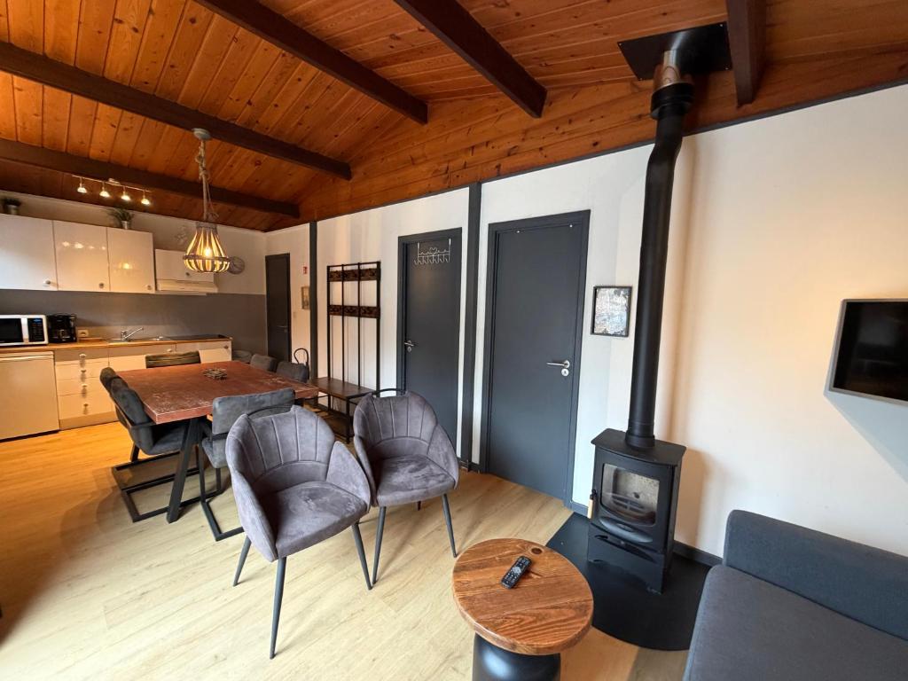 a living room with a stove and a table and chairs at Coeur de bois - 19 in Petit Mesnil