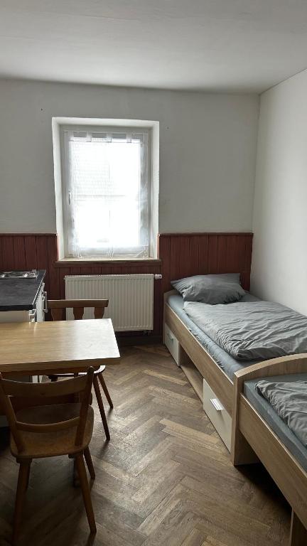 a room with two beds and a table and a window at Gasthaus Wipfler in Villenbach