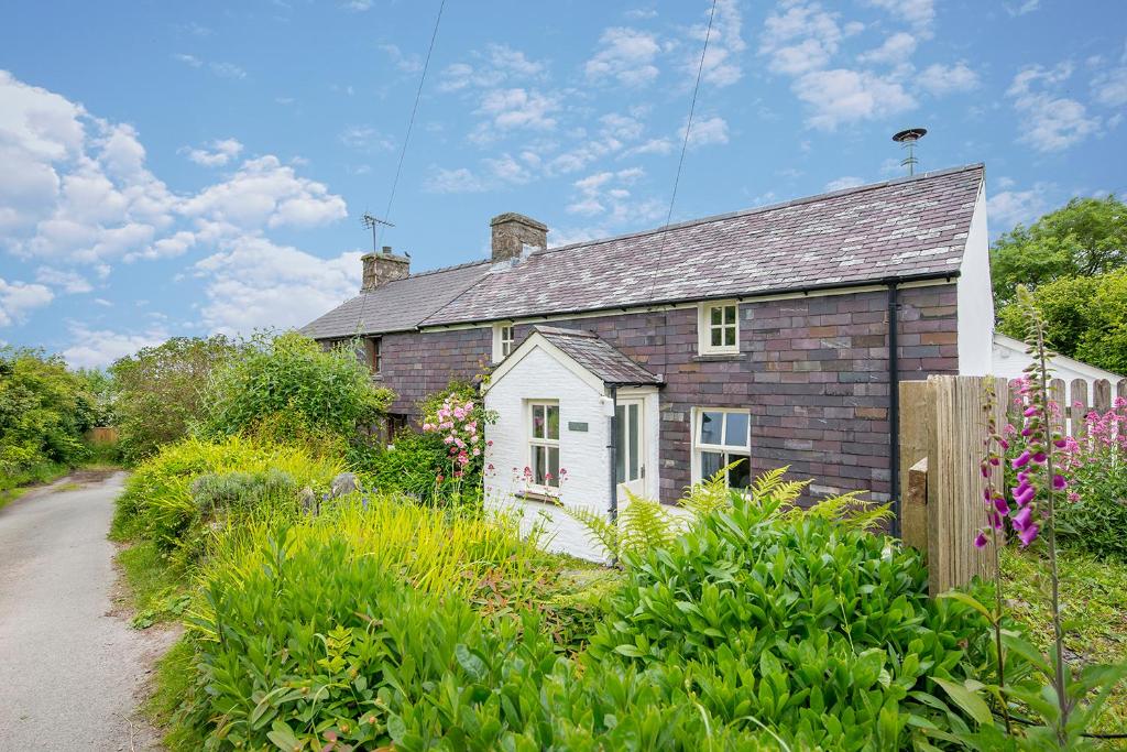 an old brick house in the middle of a garden at Ty Top in Newport