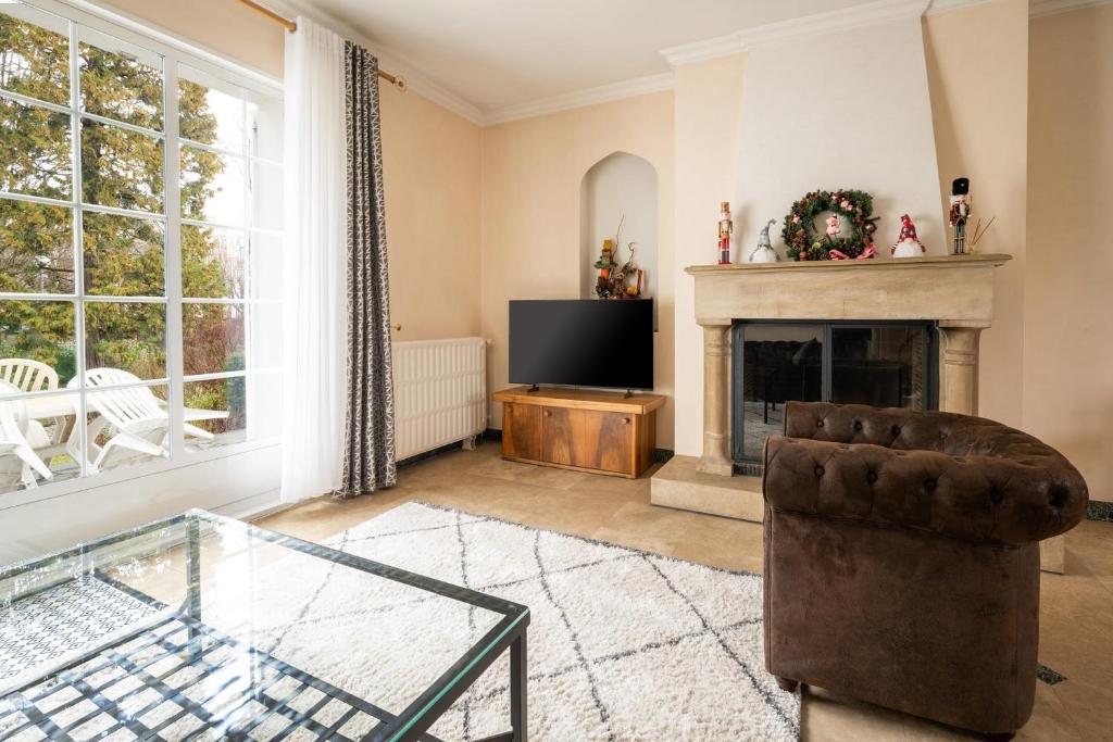 a living room with a fireplace and a chair at Maison Le Reflet de Marne - Welkeys in Vaires-sur-Marne