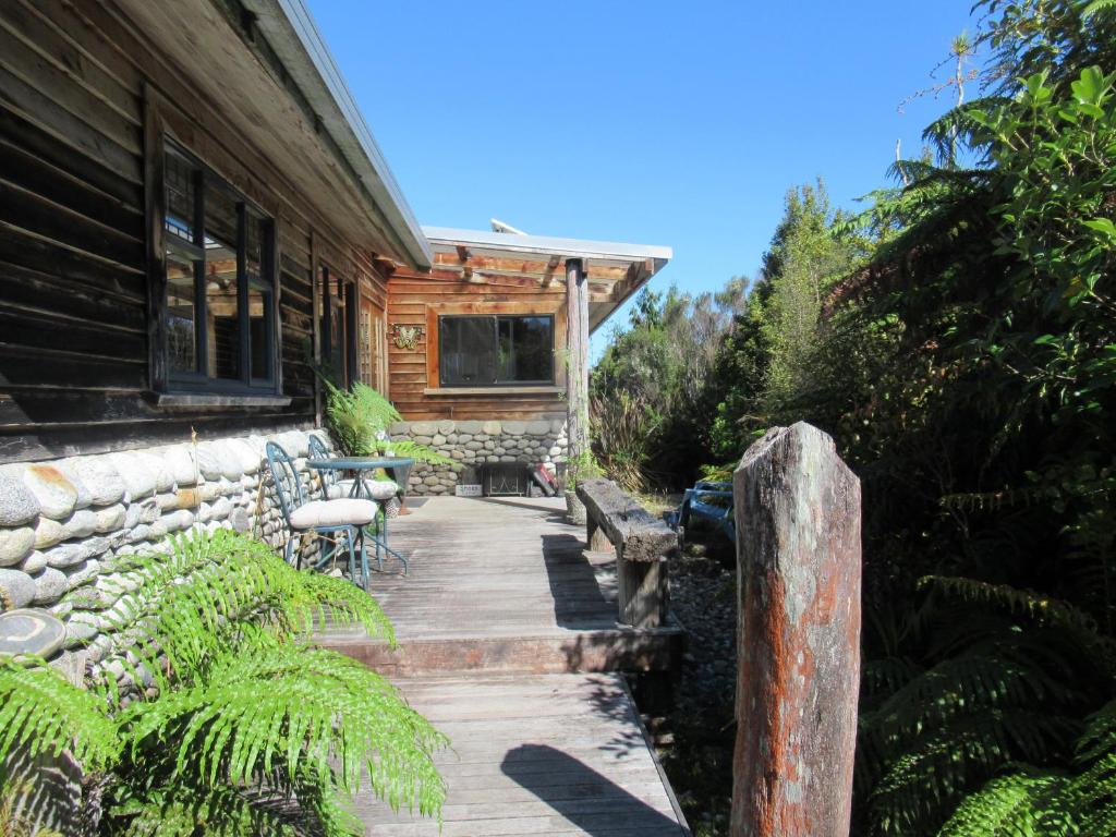 a porch of a log cabin with a table and chairs at Beaconstone - your perfect escape in Charleston