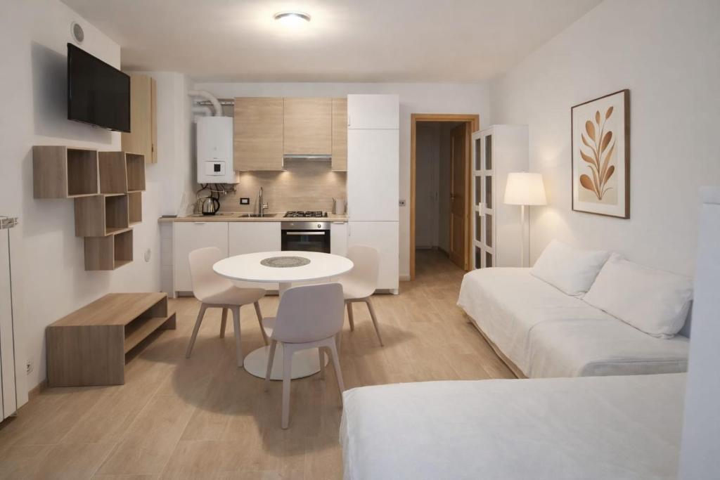 a living room with a white couch and a table at Dolomiti Relax Home in Perarolo di Cadore