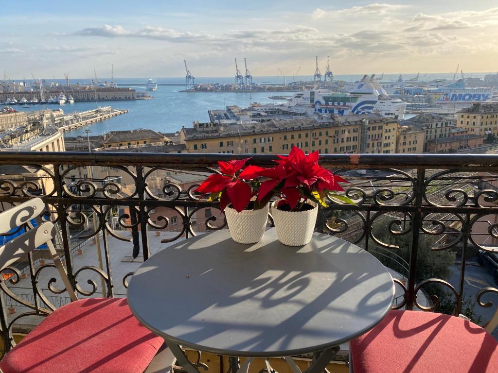 a table with two red flowers on a balcony at B&B Luci del porto in Genoa