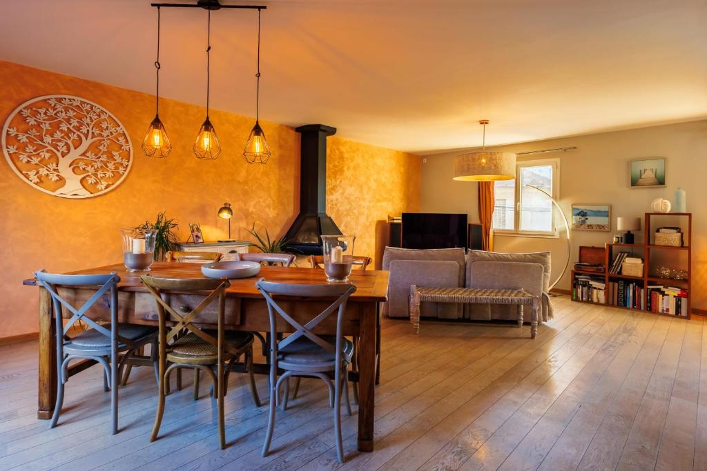 a living room with a table and chairs and a couch at Maison Flammarion - Welkeys in Avignon