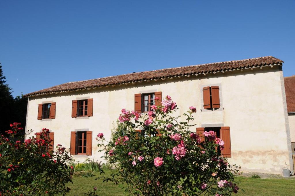 an old house with flowers in front of it at Le refuge de théoline in Lathus St Remy
