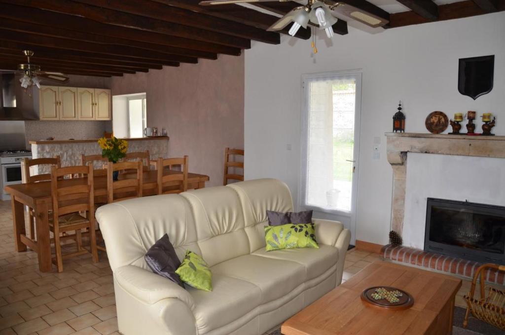 a living room with a white couch and a table at Les lilas in Lhommaizé