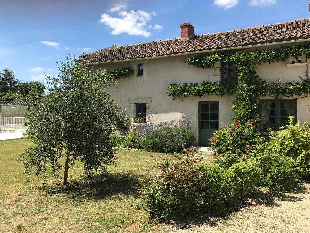 a white house with a tree in the yard at Gîte lamarlière in Savigny-sous-Faye