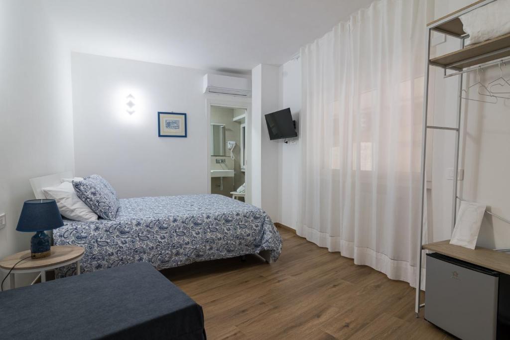 a small room with two beds and a television at Joseph's House Accommodation in Civitavecchia