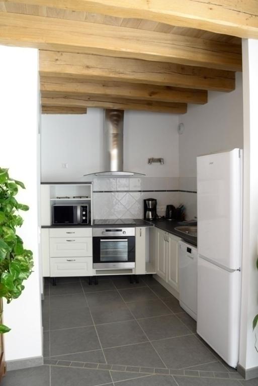 a kitchen with white appliances and a wooden ceiling at Gîte de la tonnelle in Saint-Georges-lès-Baillargeaux